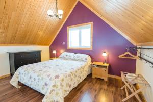 卡普沙Chalets Valmont的一间卧室配有一张床和紫色的墙壁