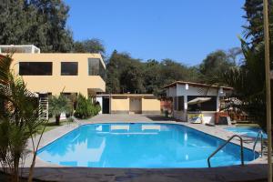 谢内吉亚区Centro Campestre Qawisqa的房屋前的游泳池