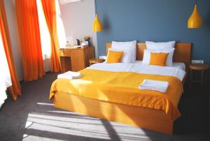 敖德萨Beehive Hotel的一间卧室设有一张大床,拥有橙色和蓝色的墙壁