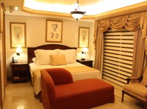 卡门城皇家庄园酒店的配有一张床和一把椅子的酒店客房