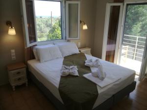 斯科派洛斯Rastoni Guest House Skopelos的一张带窗户的白色弓床