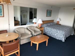 大洋城Beachcomber Motel的配有床、椅子和桌子的酒店客房