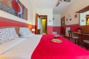 莱切Aurora Rooms的一间卧室配有一张带红毯和两杯葡萄酒的床