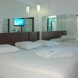São Gonçalo do Amarante艾勒依埃拉汽车旅馆（仅限成人）的一间卧室设有两张床,墙上配有电视。