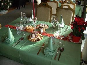 博兹达尔鲁道夫运动酒店的一张桌子,上面有带食品和酒杯的绿桌布