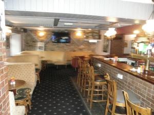 卡文Fitzpatrick's Tavern and Hotel的餐厅设有酒吧,配有木桌和椅子
