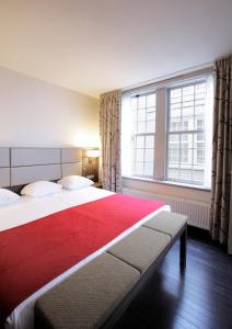 阿姆斯特丹NH酒店的一间卧室设有两张床和大窗户