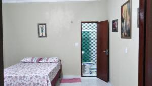 阿拉卡蒂Chalés Porto do Céu的一间卧室配有一张床,一扇门通往浴室