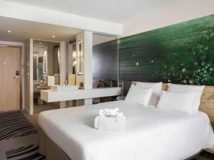 鲁瓦西昂法兰西巴黎戴高乐机场诺富特酒店的一间带白色大床的卧室和一间浴室