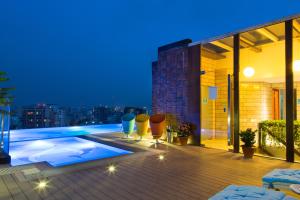 达卡六季酒店的一座带游泳池的建筑的晚上阳台
