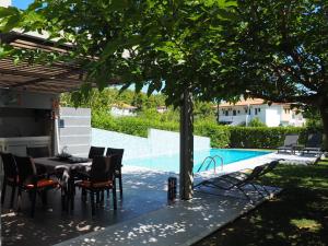 帕利乌里翁Deluxe 3BD Pool Villa in Chrousso beach Paliouri的游泳池旁树下的桌椅