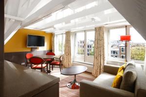 阿姆斯特丹NH酒店的客厅配有沙发和桌子