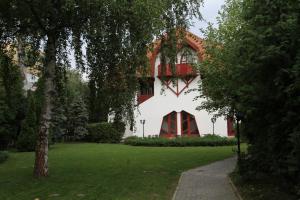 巴拉通雷勒Grantek Üdülőház的一座拥有红色和白色外墙的建筑,拥有绿色庭院