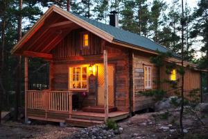 帕尔加斯Brännskär Cottages & Glamping的树林里的小木屋,灯火通明