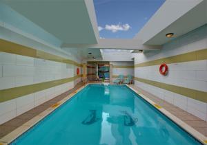 沙迦Sharjah Palace Hotel的一座带天花板的建筑中的游泳池