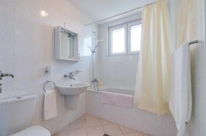 金沙白鸽别墅酒店的浴室配有盥洗盆、卫生间和浴缸。