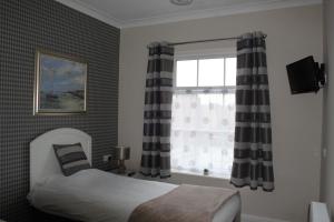 纽尼顿Abbey Grange Hotel的一间卧室配有床和带窗帘的窗户