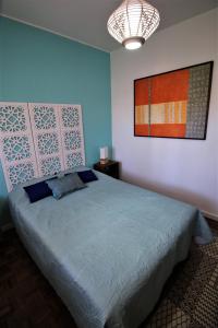 塞图巴尔Casa70的卧室配有一张床,墙上挂有绘画作品