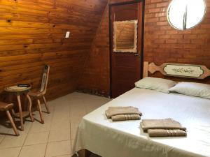 康赛瓦托利亚Chalés Verde Vida的一间卧室配有两张带毛巾的床