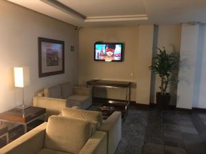 南卡希亚斯Wall Street Flat Service的带沙发的客厅和墙上的电视