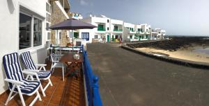 奥尔索拉Casa El Charco的海滩上带椅子和遮阳伞的阳台