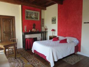 Tourville-sur-SienneLe haut Manoir的一间卧室设有一张床和红色的墙壁
