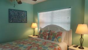 基韦斯特寇特妮之家历史小屋酒店的一间卧室配有一张带两盏灯的床和一扇窗户。