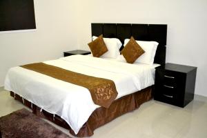 哈费尔巴廷الخربوش للشقق المخدومة的卧室配有一张带白色床单和枕头的大床。