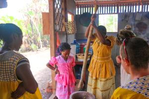 霍普金斯Palmento Grove Garifuna Eco-Cultural & Healing Institute的一群人站在厨房周围,有一名妇女