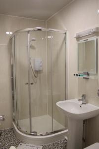 纽尼顿Abbey Grange Hotel的带淋浴和盥洗盆的浴室