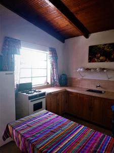 San Lucas TolimánPink house的厨房配有炉灶、水槽和窗户。