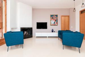 孔韦尔萨诺Alchimia Apartment的客厅配有2把蓝色椅子和电视