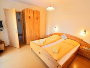 圣卡尼兹厄尔布尼斯波尔霍夫阿克酒店的一间卧室配有一张大木床,铺有黄色床单