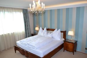 玛利亚采尔圣灵酒店的卧室配有一张带吊灯的大型白色床。