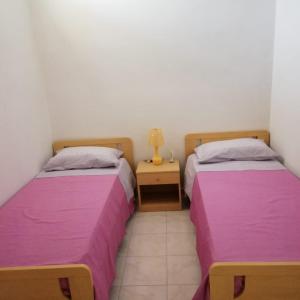波托帕洛Casa del sole的紫色床单的客房内的两张床