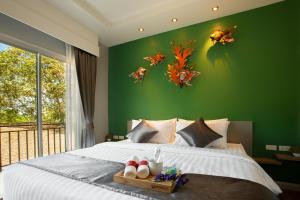 皮皮岛尤瑞普度假酒店的一间卧室设有一张大床和绿色的墙壁