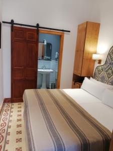 塞维利亚Santiago 15 Casa Palacio的酒店客房设有床和水槽