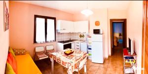 西尼斯科拉appartamento vacanze Sardegna的带桌子的厨房和带白色家电的小厨房