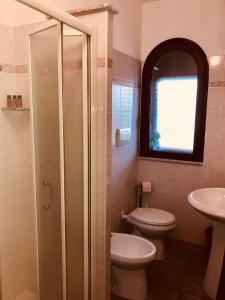 西尼斯科拉appartamento vacanze Sardegna的浴室配有卫生间、盥洗盆和淋浴。