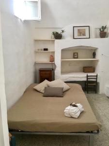 马蒂诺La Corte delle Arti的白色墙壁和架子的房间的一张床位