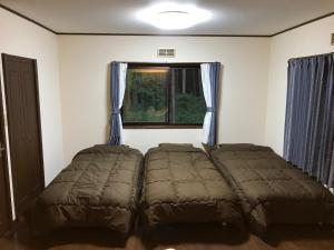 富士吉田市Forest Cottage kiki的卧室在窗户前配有两张床