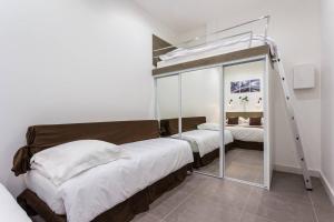 巴黎蒙马特公寓的一间卧室配有双层床和镜子