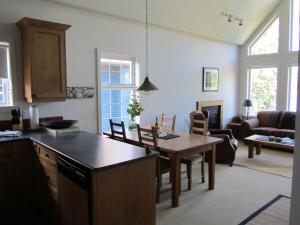 尤克卢利特水滨203公寓的厨房以及带桌椅的起居室。