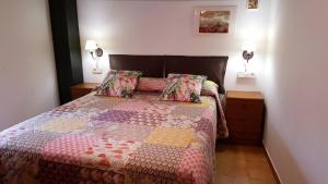 奥尔塔-德圣胡安Casa Templers的一间卧室,床上有五颜六色的被子