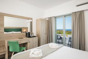 埃拉福尼西岛Glykeria Hotel的配有一张床、一张书桌和一扇窗户的酒店客房