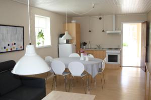 森讷堡桑德堡卡尔韦斯特马克度假屋的厨房以及带白色桌椅的用餐室。