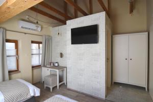 卢布尔雅那Janez Rooms的一间白色砖墙带电视的卧室