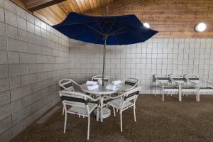 Mounds View阿美瑞辛酒店的一张桌子、椅子和一把蓝色的伞