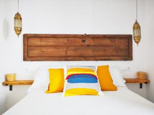 贝赫尔-德拉弗龙特拉La Zalamera的卧室配有白色的床和色彩缤纷的枕头