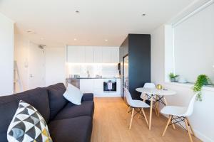 奥克兰Brand New Auckland Apartment的客厅配有沙发和桌子